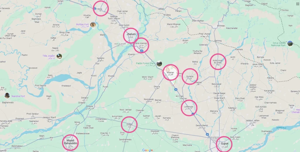 Map showing a region with several cities marked by pink circles. Notable cities include Jhelum, Gujrat, and Mandi Bahauddin. Major roads and rivers are visible.