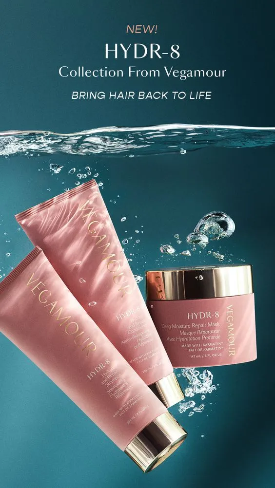 Pink packaging of Vegamour's HYDR-8 hair collection, featuring two tubes and a jar with gold caps, floating in water, conveying hydration and luxury.